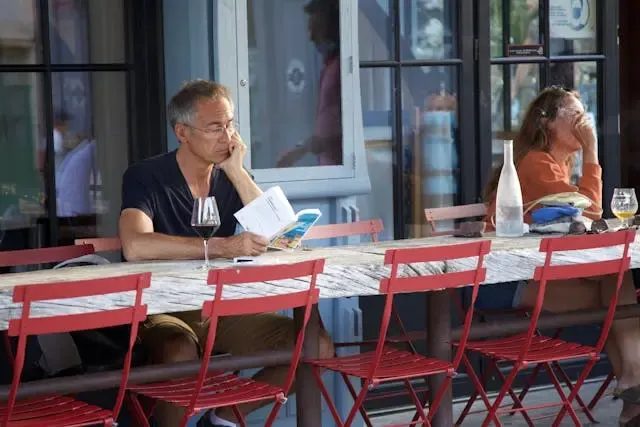 Photo d'une personne sur une terrasse à La Rochelle lisant un livre
